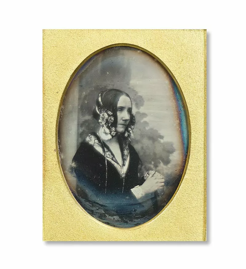 Early photograph of Ada Lovelace in an oval gilt frame, wearing a dark dress and a lace collar, her hands folded