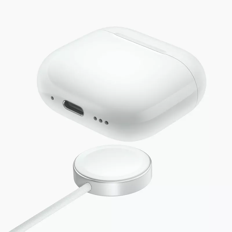 The AirPods 5 wireless charging case next to an Apple Watch charging puck
