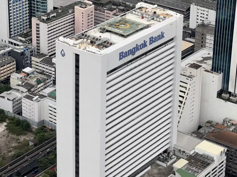 Aerial view of the tall white Bangkok Bank headquarters tower on Silom Road with its name on the top floor, among other city buildings