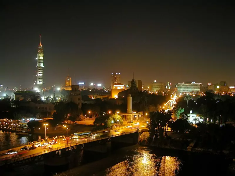 Cairo at night, with the lit Cairo Tower, a bridge with traffic over the Nile and city lights reflected in the river