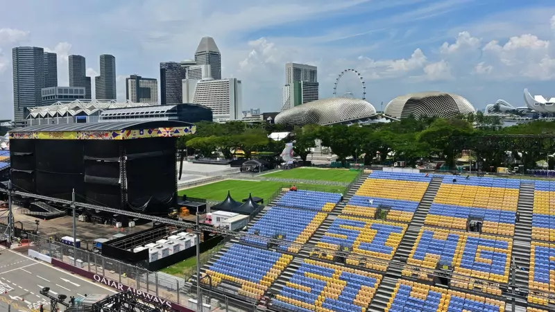 Grandstands beside a street with the domed Esplanade theatres and the Singapore Flyer behind them