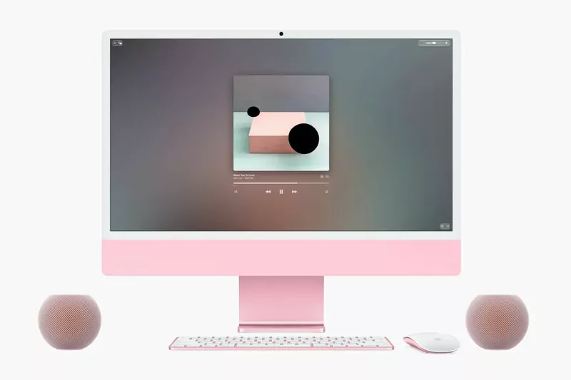 A pink iMac on a desk with a pink HomePod mini 2 on each side, used as stereo speakers