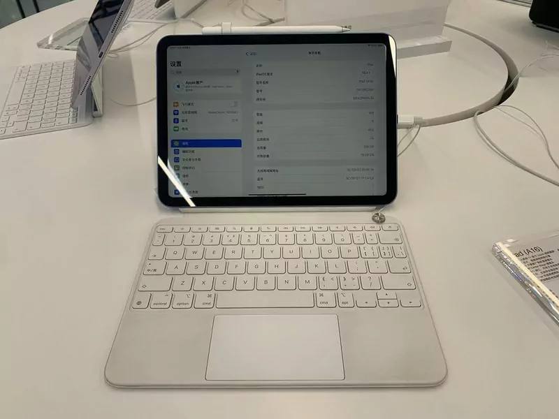 An iPad with the A16 chip on a white Magic Keyboard Folio on a store display table