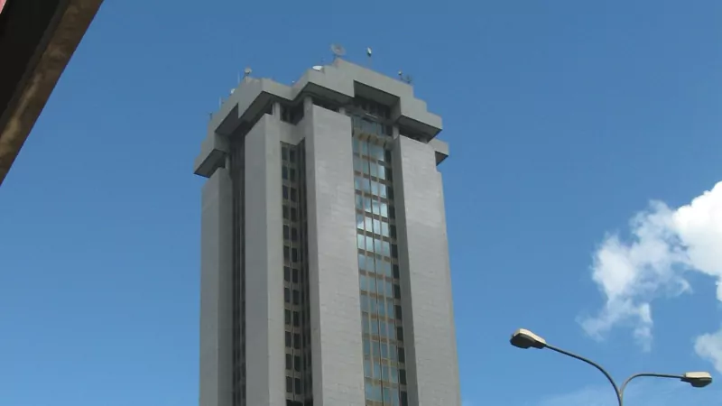The upper floors of the grey Times Tower in Nairobi, the Kenya Revenue Authority's head office, against a blue sky with white clouds