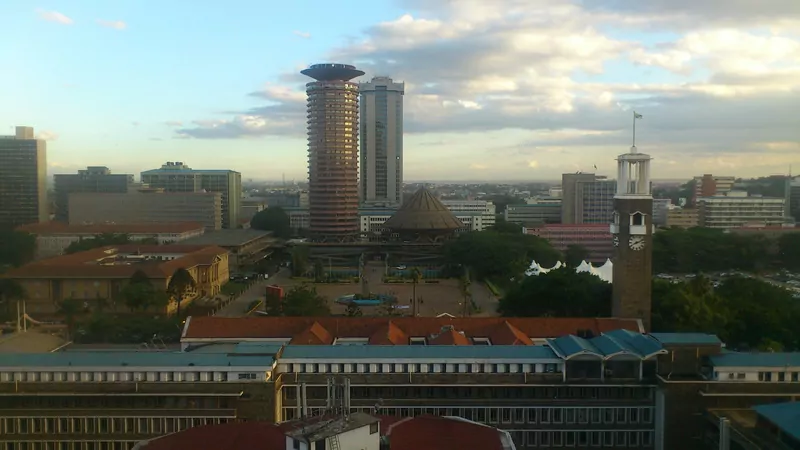 The Nairobi skyline at dusk with the round Kenyatta International Convention Centre, a grey office tower behind it and a clock tower at right