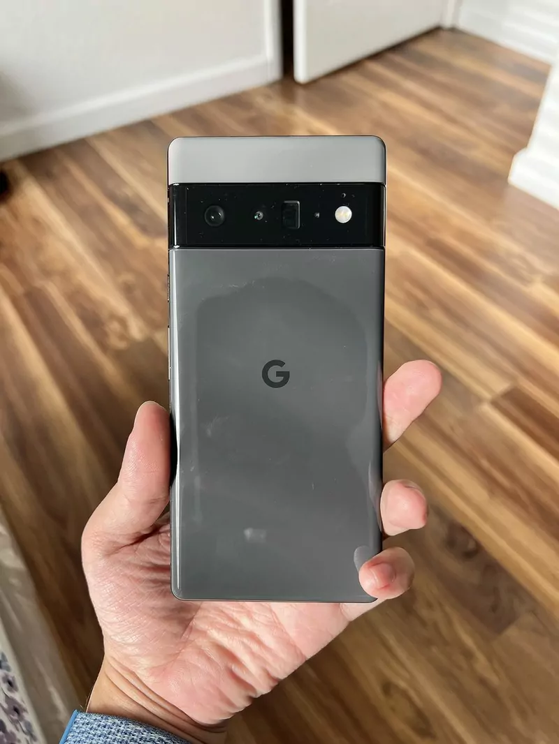 A hand holding the back of a grey Google Pixel 6 Pro with its wide camera bar