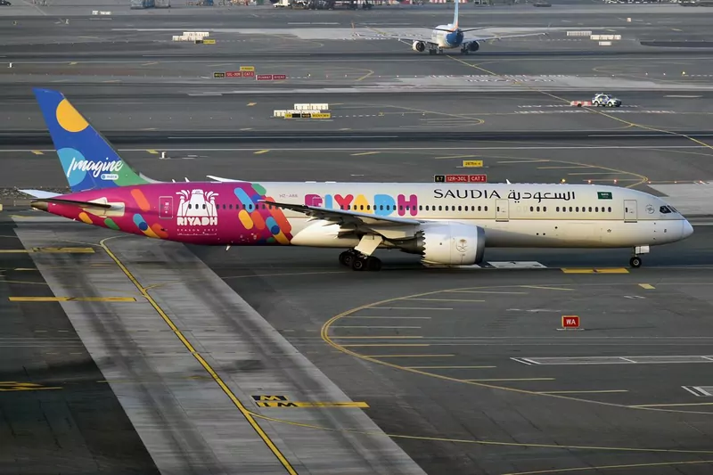 A Saudia Boeing 787 painted in colourful Riyadh Season livery taxiing at an airport