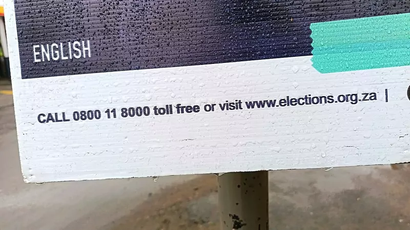 The bottom strip of an Electoral Commission election poster reading Call 0800 11 8000 toll free or visit www.elections.org.za, fixed to a pole