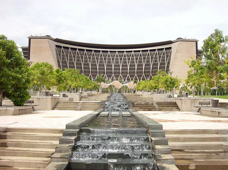 The curved front of the Finance Ministry complex in Putrajaya behind a stepped water feature, with trees on both sides