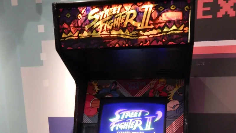 The glowing marquee of a Street Fighter II arcade machine above its screen, which shows the Street Fighter II Hyper Fighting title