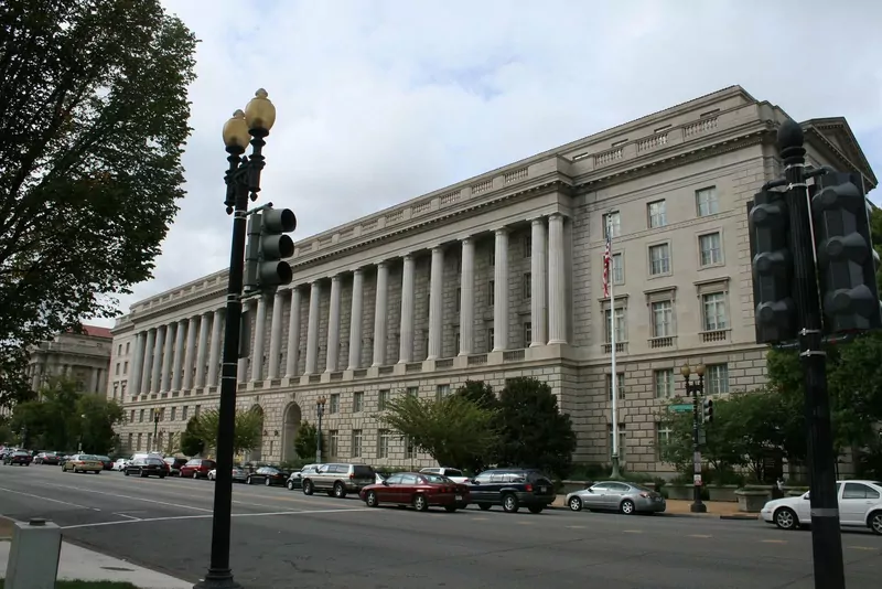 The large stone Internal Revenue Service building with tall columns on Constitution Avenue in Washington, D.C., seen from the street
