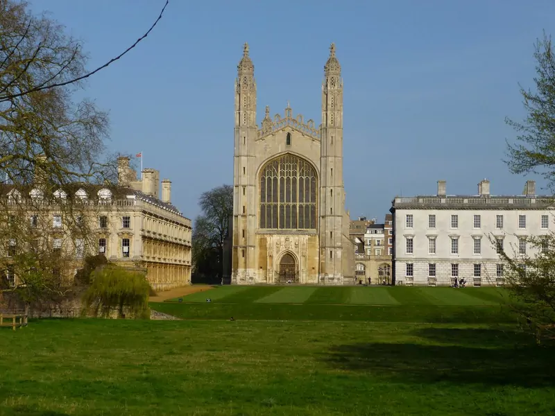 The tall Gothic chapel of King's College, Cambridge, seen across a wide lawn with college buildings on either side