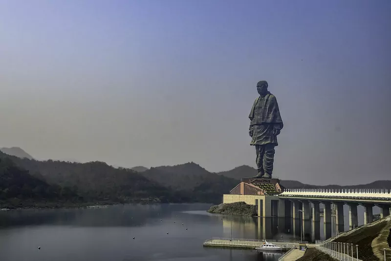 The Statue of Unity, a giant statue of Sardar Vallabhbhai Patel, standing above a lake and hills in Gujarat